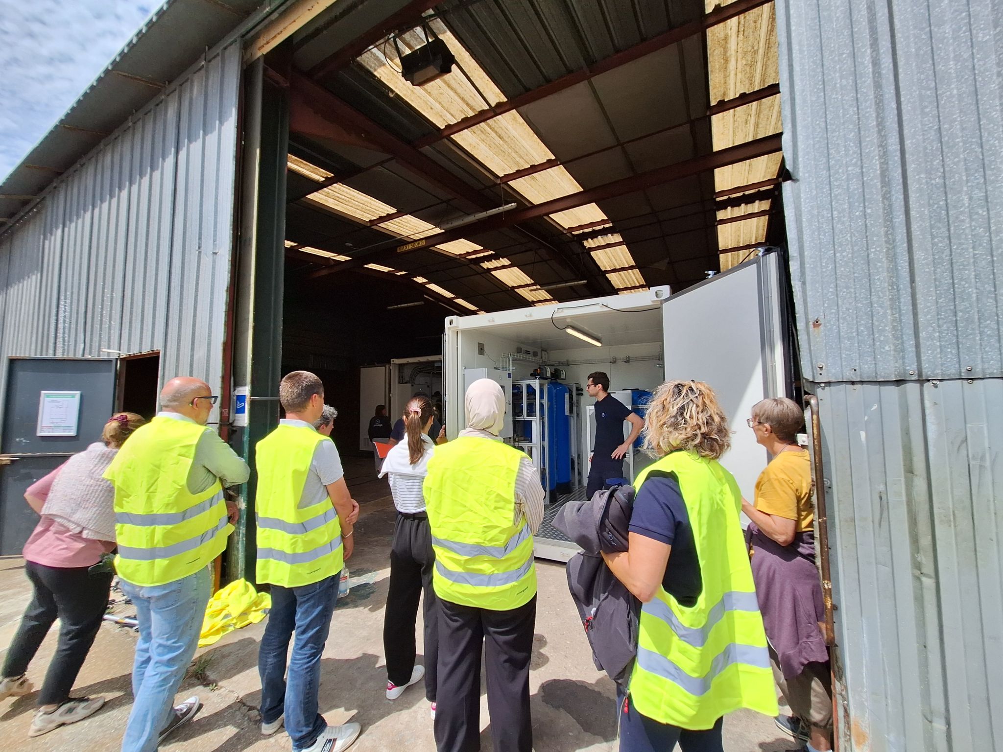 Les participants à la marche de nettoyage écoutent un technicien qui leur parle des PFAS dans l'unYo de l'atelier d'InovaYa.