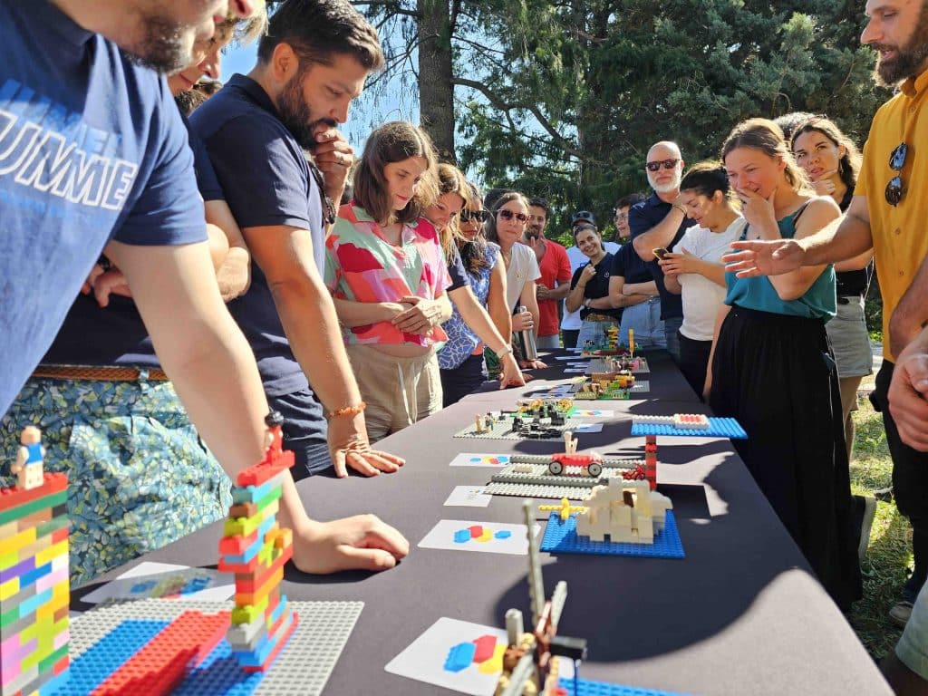 inovaYa employees gathered around the table for a Lego activity during the 2025 summer seminar.